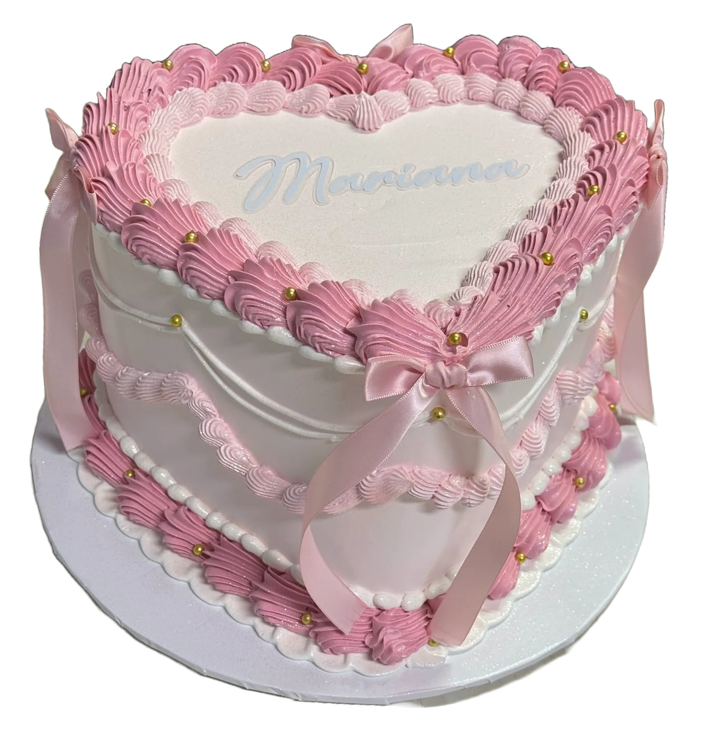 Pastel de corazón blanco y rosa con moños y perlas doradas